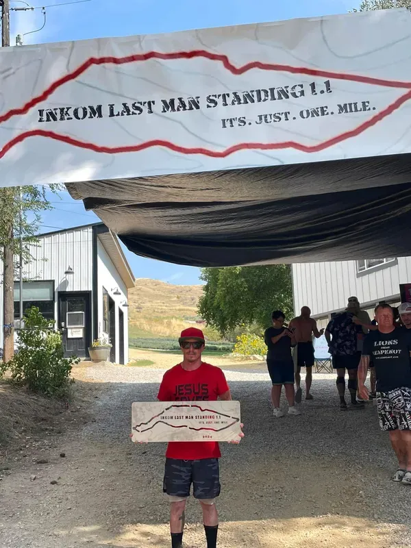 Three men smiling at the recovery area, resting with feet up on a cooler